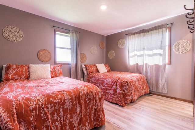 bedroom with baseboards and wood finished floors