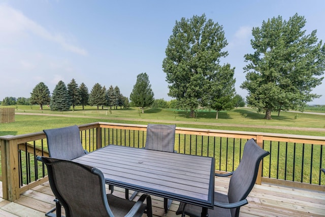 wooden terrace with outdoor dining space and a lawn