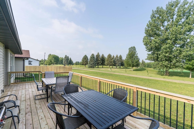 wooden terrace with outdoor dining area, a lawn, and fence