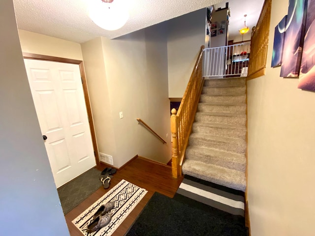 staircase with a textured ceiling