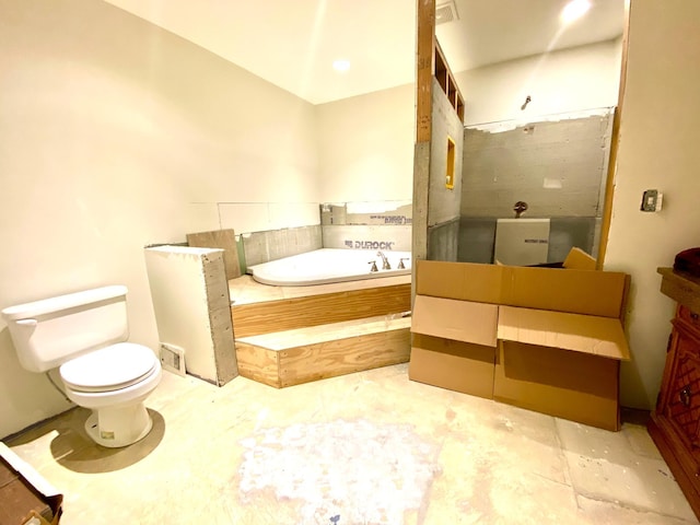 bathroom featuring vanity, toilet, and a washtub