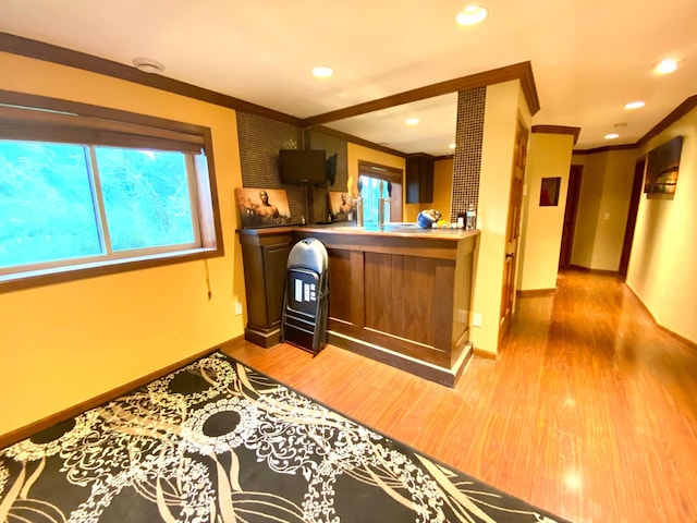 kitchen with crown molding, kitchen peninsula, and hardwood / wood-style floors