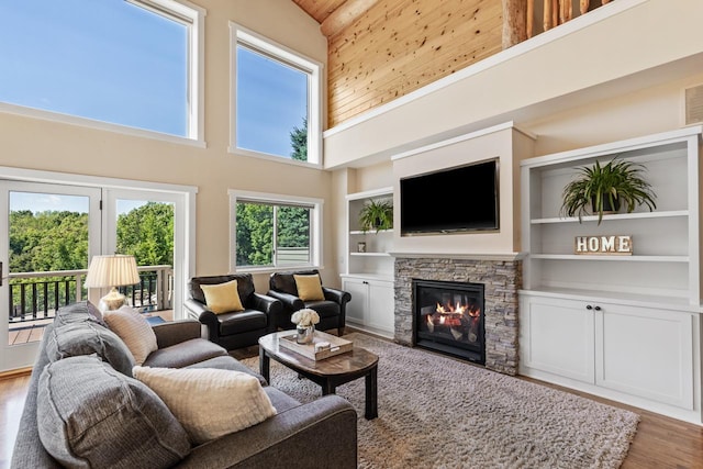 living room featuring high vaulted ceiling, a fireplace, and hardwood / wood-style floors