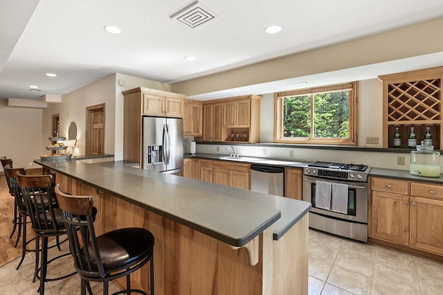 8800 Sunset Trl, Chanhassen, MN 55317 - kitchen with appliances with stainless steel finishes, dark countertops, a kitchen bar, a sink, and recessed lighting