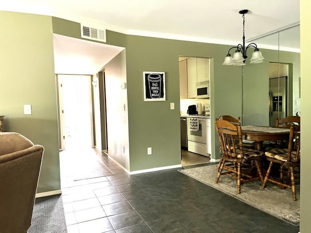 tiled dining space featuring ornamental molding and a notable chandelier