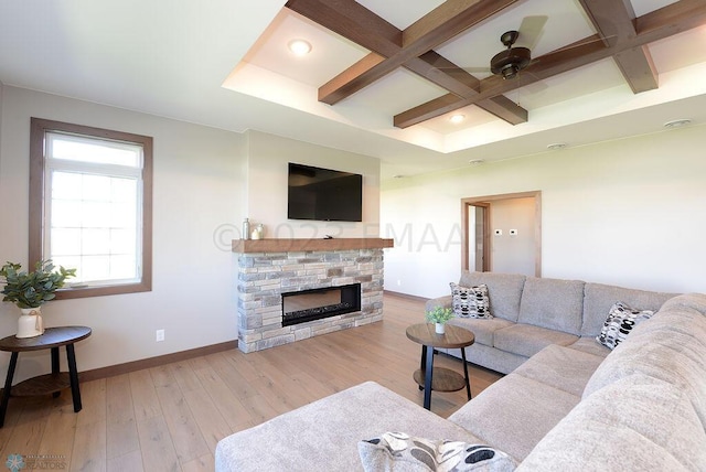 living room featuring coffered ceiling, ceiling fan, a fireplace, and light hardwood / wood-style floors