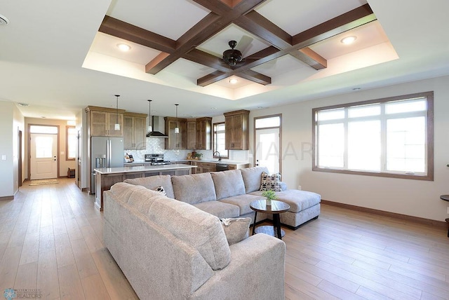 living room with light wood-type flooring, coffered ceiling, sink, and beamed ceiling