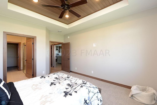 carpeted bedroom with wood ceiling, a raised ceiling, and ceiling fan