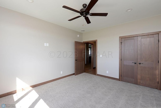 unfurnished bedroom featuring baseboards, carpet flooring, a ceiling fan, and a closet