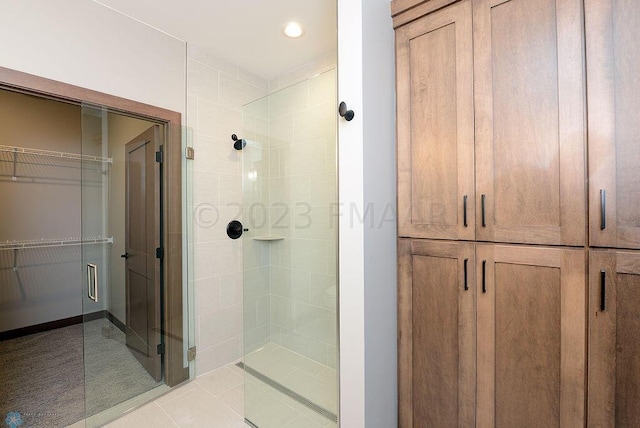 bathroom featuring a shower with shower door and tile patterned floors