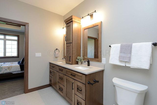 bathroom featuring connected bathroom, double vanity, toilet, and a sink