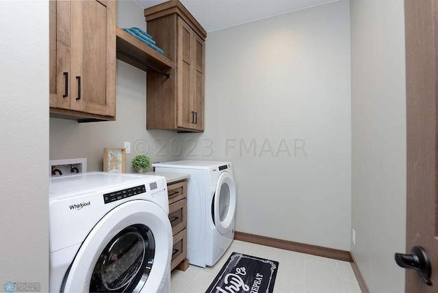 laundry room featuring cabinets, washer and dryer, and light tile patterned flooring