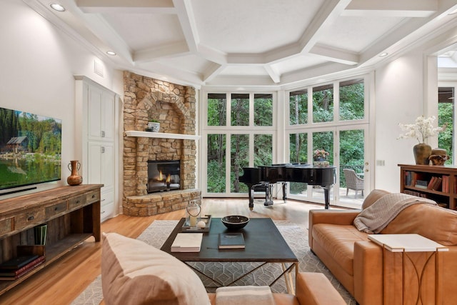 living room featuring a fireplace, light hardwood / wood-style floors, plenty of natural light, and coffered ceiling