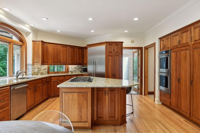 kitchen with backsplash, a center island, light hardwood / wood-style floors, and appliances with stainless steel finishes