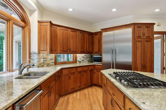 kitchen featuring crown molding, sink, light wood-type flooring, and appliances with stainless steel finishes