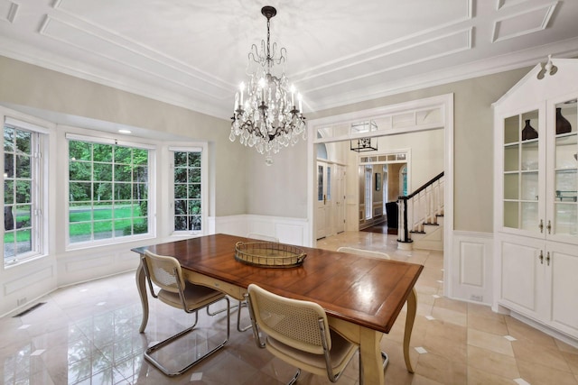 dining area with crown molding and a chandelier