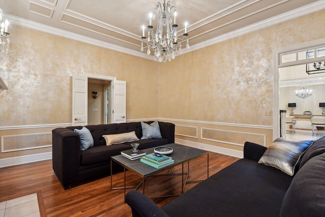 living room with hardwood / wood-style flooring, crown molding, and a notable chandelier