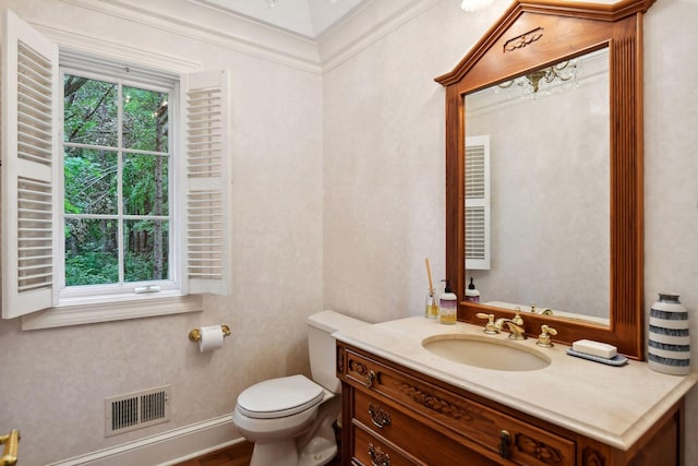 bathroom with wood-type flooring, vanity, toilet, and crown molding