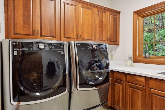 laundry area featuring cabinets, washing machine and dryer, and sink