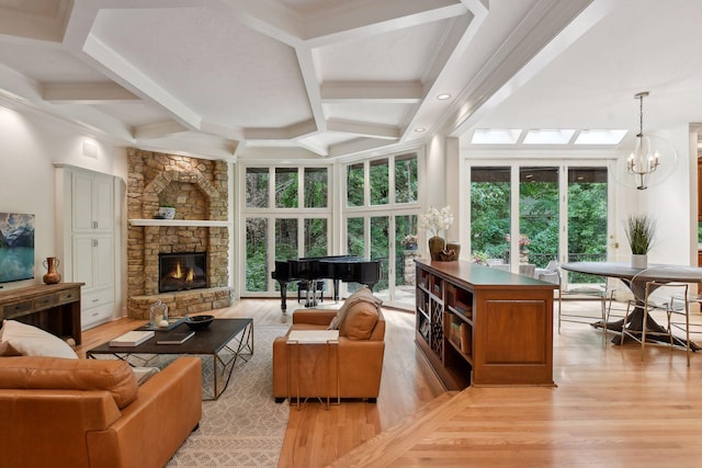 sunroom featuring beam ceiling, coffered ceiling, a notable chandelier, and a stone fireplace