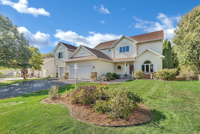 view of front of property featuring aphalt driveway, an attached garage, and a front yard