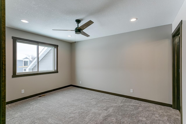 unfurnished room with a textured ceiling, carpet flooring, and ceiling fan