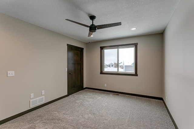 unfurnished bedroom featuring ceiling fan, light colored carpet, and a textured ceiling