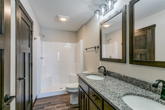 bathroom with walk in shower, vanity, toilet, and wood-type flooring