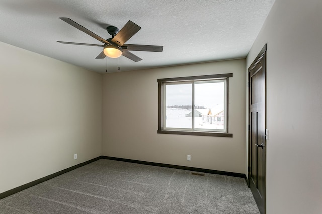 carpeted empty room featuring a textured ceiling and ceiling fan