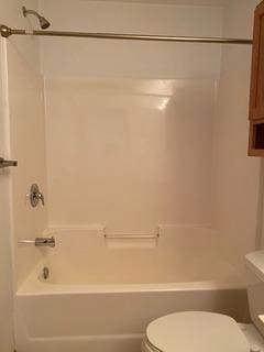 bathroom with toilet and shower / washtub combination