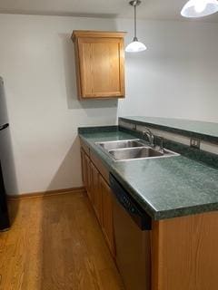 kitchen with pendant lighting, dark hardwood / wood-style flooring, stainless steel dishwasher, and sink