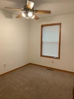 carpeted spare room with ceiling fan