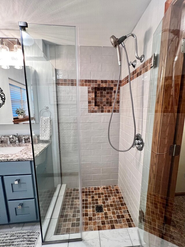 bathroom with vanity, a textured ceiling, and walk in shower