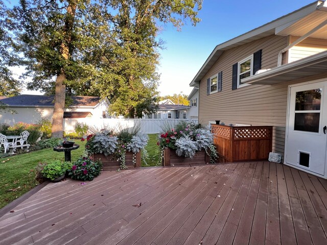 wooden deck featuring a lawn