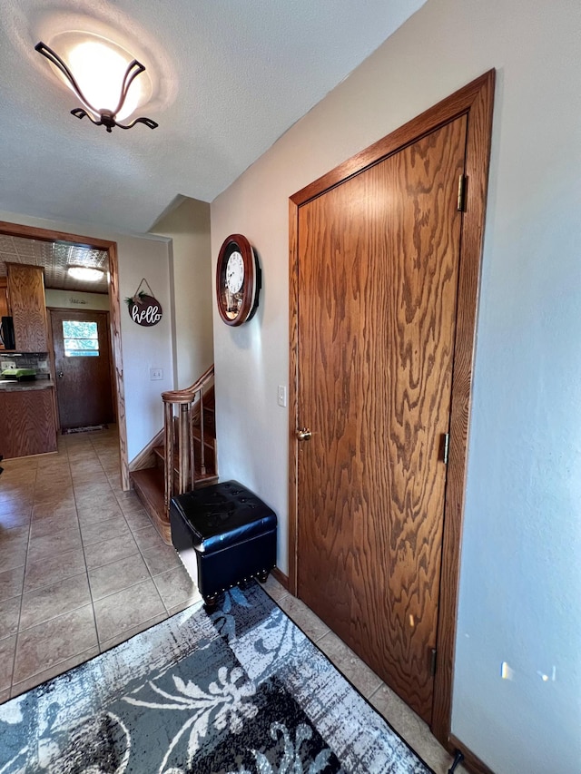 tiled entrance foyer featuring a textured ceiling