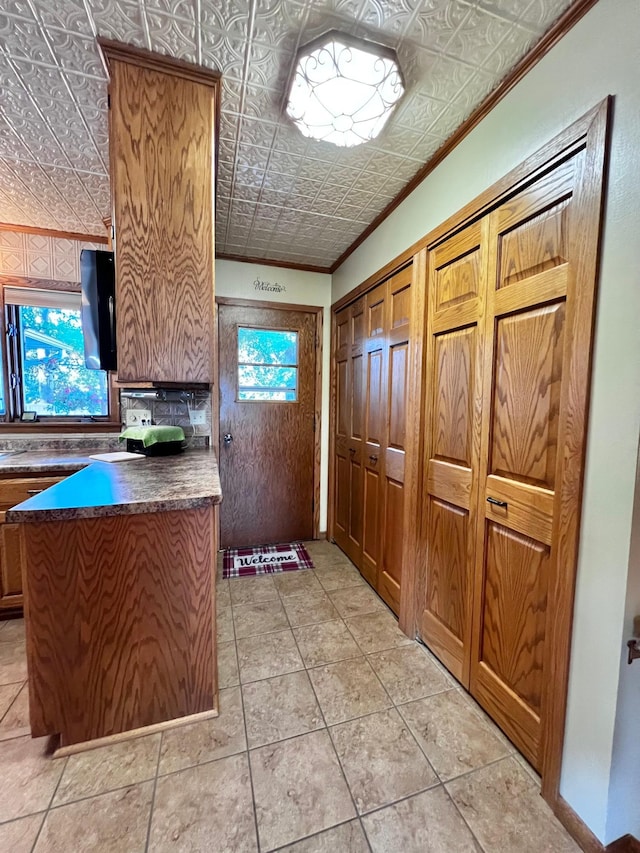 kitchen with crown molding and light tile patterned flooring