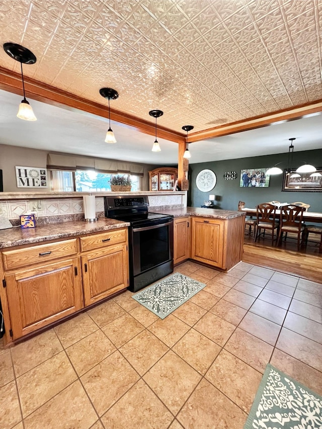 kitchen featuring black / electric stove, crown molding, kitchen peninsula, pendant lighting, and light tile patterned flooring