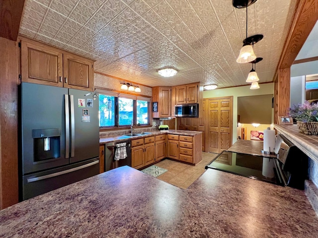 kitchen with appliances with stainless steel finishes, hanging light fixtures, ornamental molding, and sink