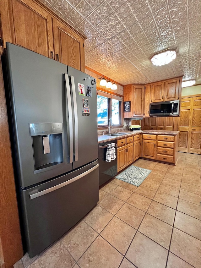 kitchen featuring appliances with stainless steel finishes, light tile patterned floors, and sink