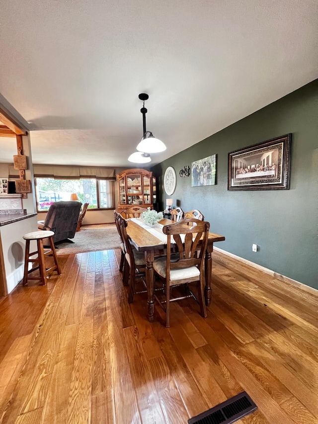 dining space with wood-type flooring