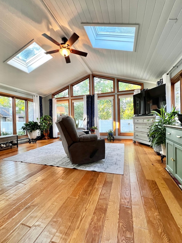 unfurnished living room with ceiling fan, light hardwood / wood-style floors, lofted ceiling with skylight, and wood ceiling