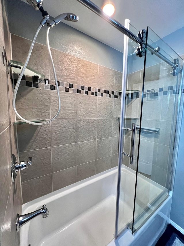 bathroom featuring combined bath / shower with glass door