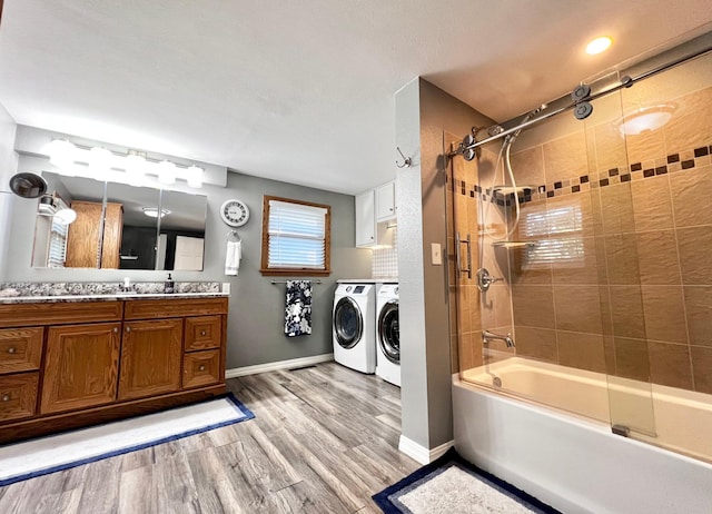 bathroom featuring separate washer and dryer, vanity, wood-type flooring, and tiled shower / bath combo