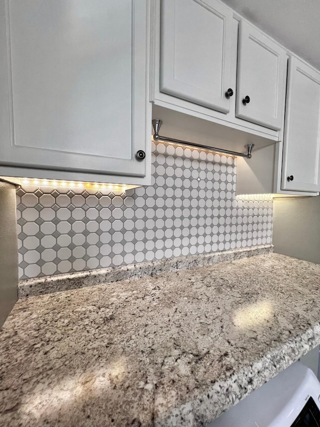 details with white cabinets and decorative backsplash