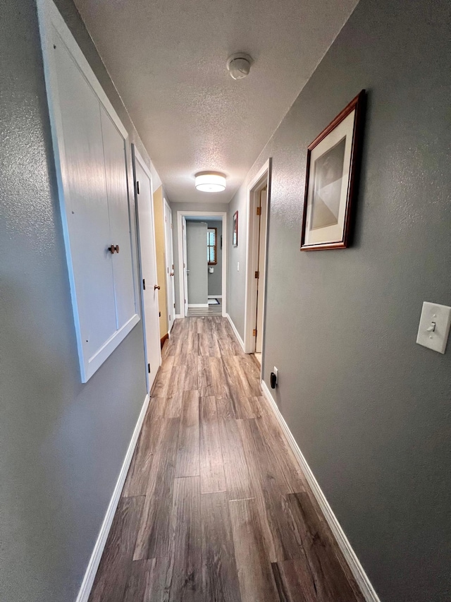 hallway featuring hardwood / wood-style flooring and a textured ceiling