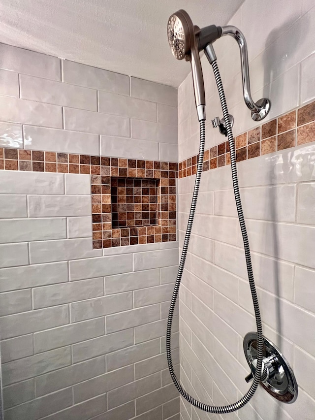 details featuring tiled shower and a textured ceiling