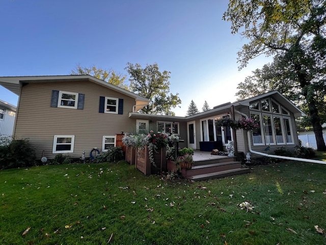 rear view of property with a lawn and a wooden deck