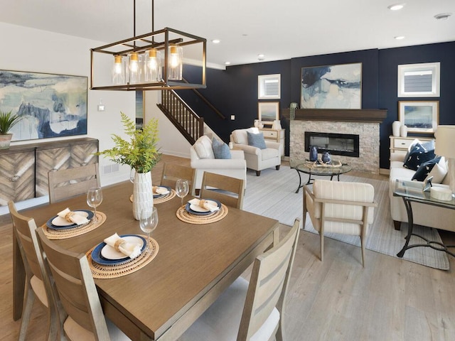 dining space featuring light hardwood / wood-style flooring and a fireplace