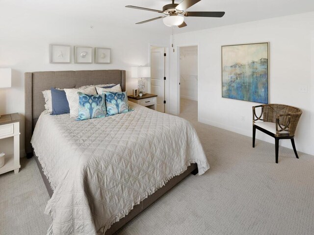 carpeted bedroom featuring a closet, a spacious closet, and ceiling fan