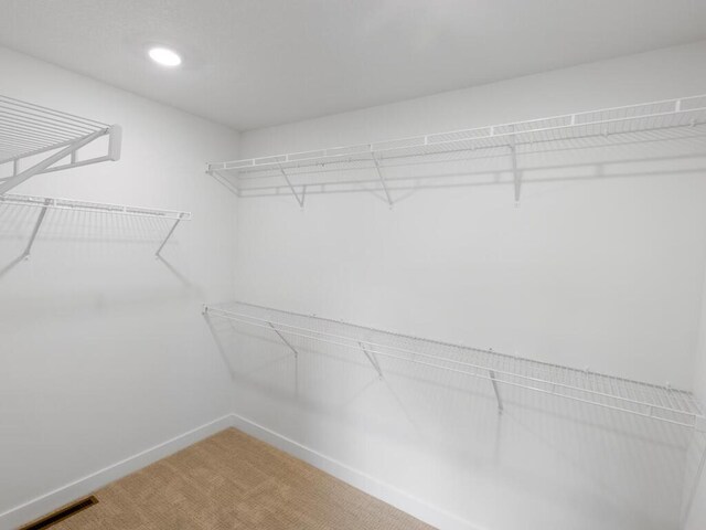 walk in closet with carpet